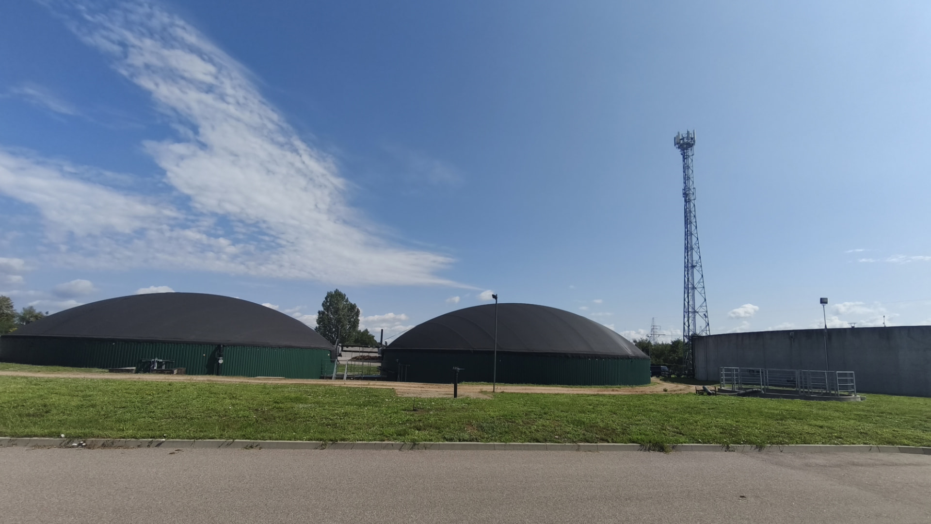 Biogazownia rolnicza — zbiorniki fermentacyjne pod błękitnym niebem