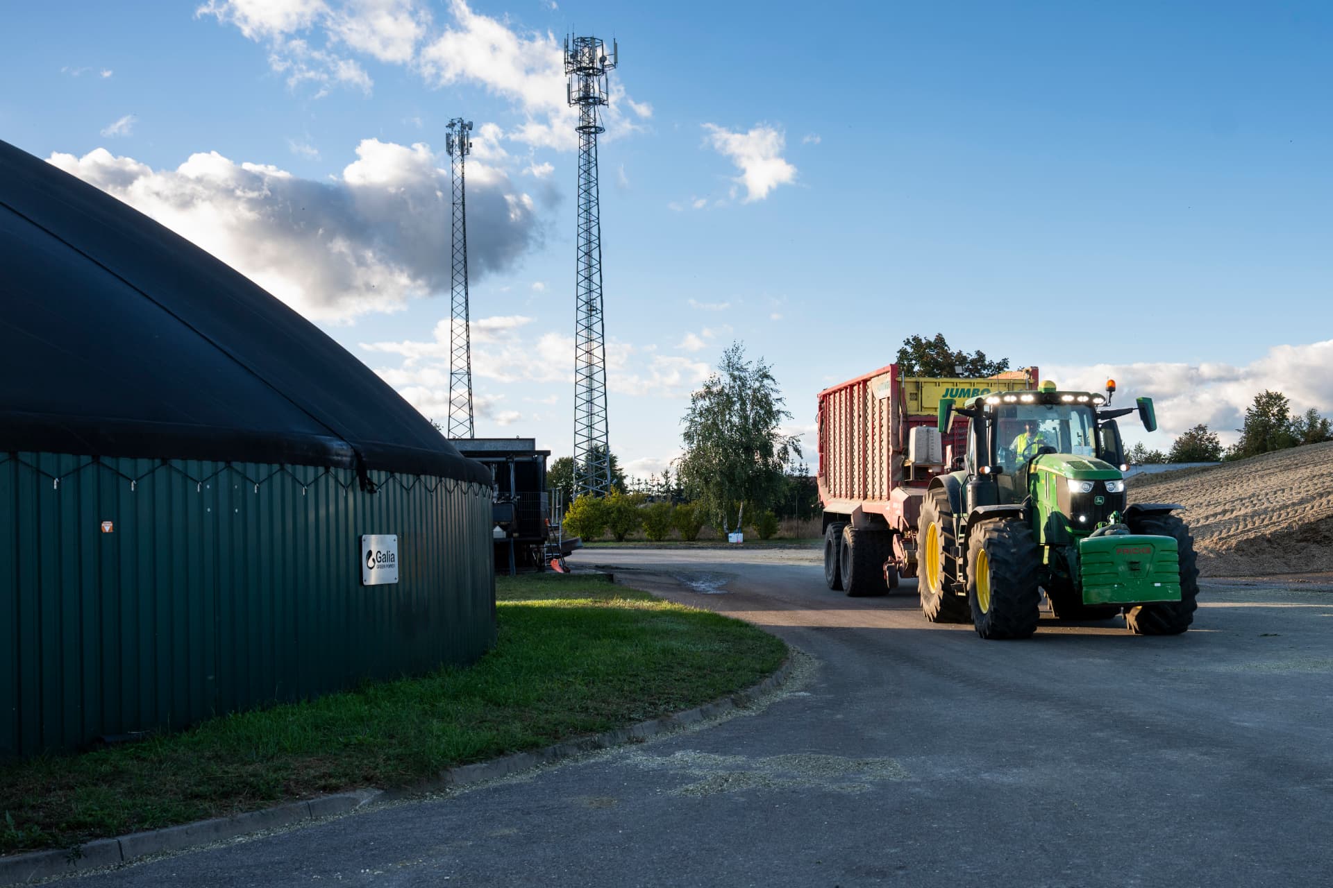 Traktor z przyczepą przy zbiornikach biogazowni Galia Green Power